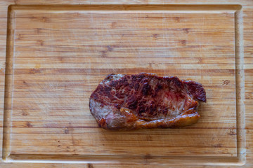 Shots of a sliced fresh rump steak with fat on  the steak on a wooden board