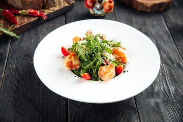 Gourmet  arugula and shrimps salad in white plate