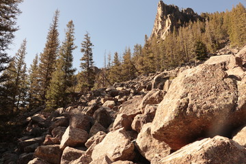 Fototapeta na wymiar Boulders and evergreens looking up at a mountain peak