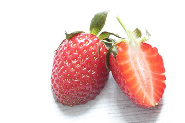 Fresh red strawberry cut in half on a white background. Healthy food