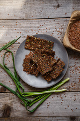 Loaves of flax green buckwheat and onion on a gray platter and a wooden table