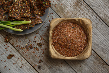 Loaves of flax green buckwheat and onion on a gray platter and a wooden table