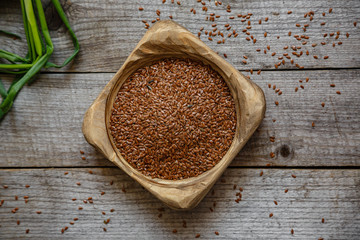 Flax seeds in a wooden bowl on a wooden table