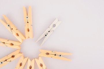 Leader concept. Think creatively. Stand out from the crowd. A silver clothespin stands out among the wooden clothespins.