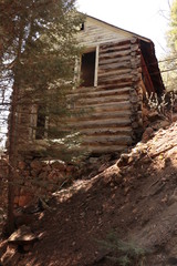 Fototapeta na wymiar Log cabin built on a hillside in the woods