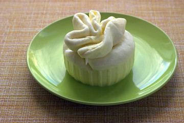 Handmade strachatella cheese with a slit on its side lies on a green plate. Side view