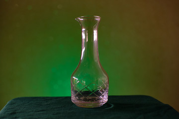 vintage glass decanter on green background