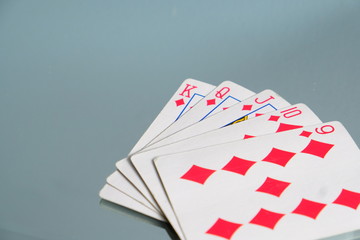 Diamond Straight Flush Playing Cards. Five card hands. Nine, Ten, jack, queen, king on blue grey background. Poker hand and card games. Diamond suit almost a royal flush, gambling. Las Vegas