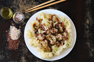 Cauliflower with soy sauce and spices on a plate. View from above. Diet food. Vegan lunch. Healthy eating
