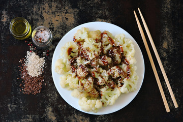 Cauliflower with soy sauce and spices on a plate. View from above. Diet food. Vegan lunch. Healthy eating