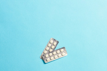 Two plates with pills on a blue background. Insomnia, a choice of drugs, vitamins. Flat lay, top view