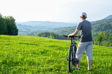 A man on a bicycle looks into the distance