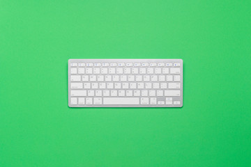 Keyboard on a green background. Business concept, writer, freelance, journalist. Flat lay, top view