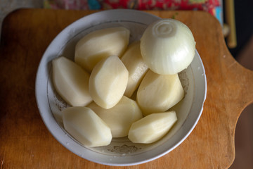 Peeled raw potatoes and onions