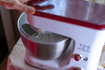 The mixer whips the dough to prepare it for baking.