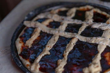 Pie with jam on a baking sheet before baking