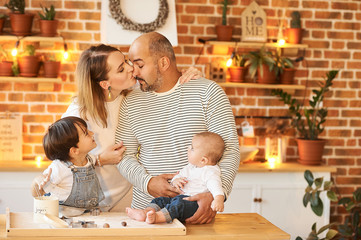 young beautiful family having fun and cooking in the sunny kitchen