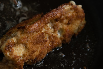 Frying pieces of chicken in breadcrumbs in a pan