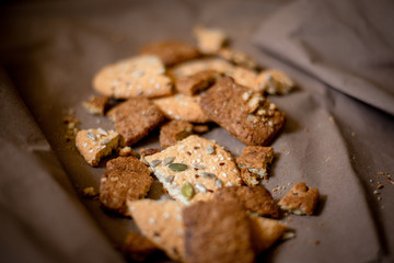 chocolate and white cookies with sunflower seeds and sesame seeds on a brown background, top view
