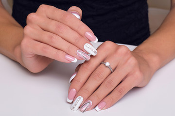 Female hands with stylish and luxury french manicure nails and ring on fingers. Wedding style.