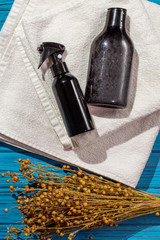 bath accessories and a bouquet of linum (flax)r lie on folded white towels on a blue wooden background. 