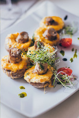 Stuffed mushrooms filled with cheese, mushroom stems, fresh cherry tomatoes and microgreen.