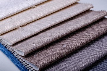 Close up water drop on gunny textile. Bright collection of gunny textile samples. Fabric texture background.