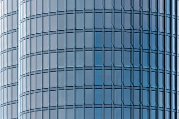 Fototapeta premium Fragment of modern rounded high-rise building of glass and concrete. Abstraction geometry pattern.