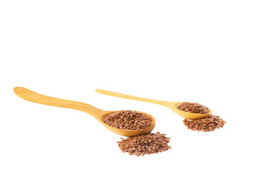 flax seeds spill out of a wooden spoon isolated on a white background .