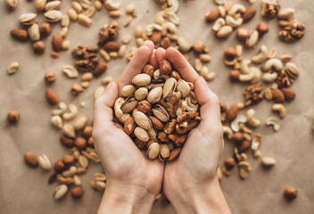 Different types of nuts, nut mix of almonds, hazelnuts, cashews, peanuts in hands. 