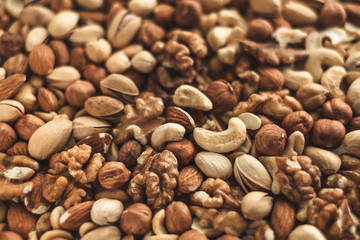 Different types of nuts, nut mix of almonds, hazelnuts, cashews, peanuts texture background. Close up