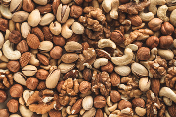 Different types of nuts, nut mix of almonds, hazelnuts, cashews, peanuts texture background. Close up
