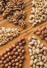 Different types of nuts, nut mix of almonds, hazelnuts, cashews, peanuts on a wooden board. Close up