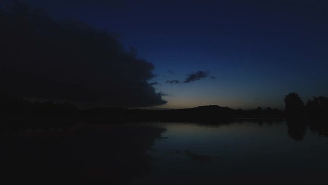 Cinemagraph - Apocalyptic dramatic dark clouds and sunset over lake, time-lapse.
