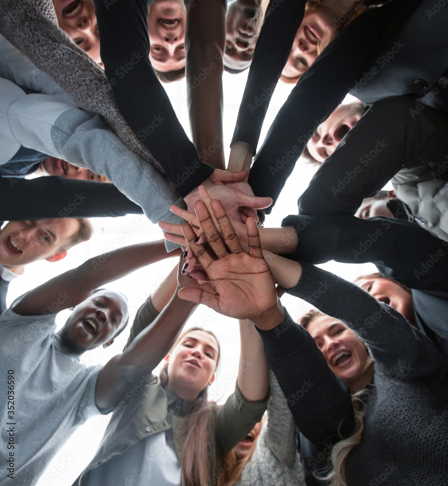 Sticker bottom view. group of happy young people making a stack of hands