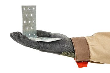 Galvanized metal mounting bracket with holes lies in palm of worker hand in black protective glove and brown uniform isolated on white background