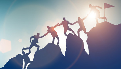 Concept of teamwork with team climbing mountain top