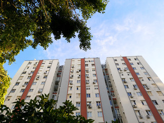 A view at a detail of a modern white apartment building, with blue sky background
