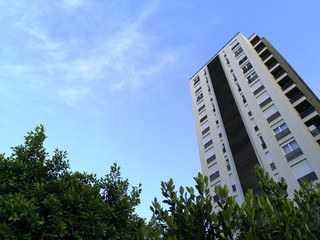 A view at a detail of a modern white apartment building, with blue sky background
