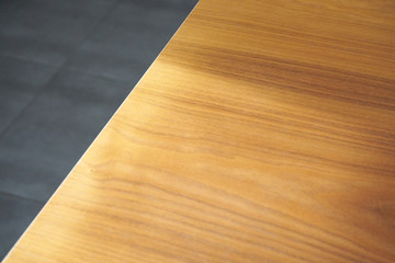 Rays of light on a rough wooden table and tiling in the background