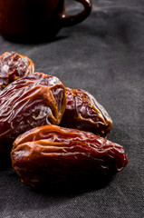 Big luxury dried date fruit on the dark surface, kurma ramadan kareem concept, close up.