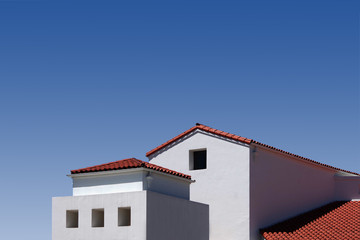 white building with red roofs and blue sky