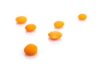 Orange lentils seeds row isolated on white. Pile pea nutrition background. Healthy lentil food, vegetarian diet or clean eating concept with antioxidant, omega-3, protein.