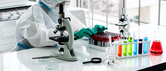 banner picture of scientist in personal protective equipment or ppe doing research and experiment...