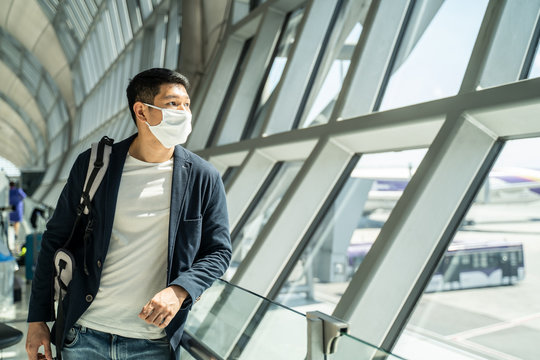 Asian Traveler Business Man Wear Face Mask Waiting To Board Airplane.