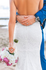 the wedding coulple were sranding and embracing each other on the romantic beach showing their for each other remembering the day they were married forever