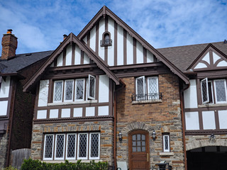 Facade of older Tudor design home with half timbered decorations and leaded glass windows