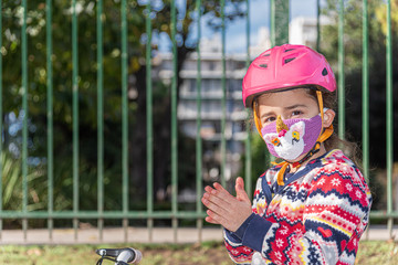 Cautious and optimistic return to normal. 6 years old happy caucasian little girl riding her...