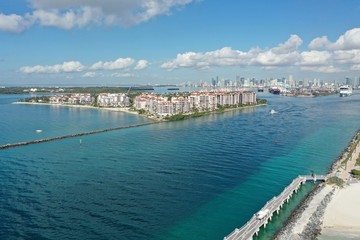 Naklejka na ściany i meble Aerial view of Fisher Island, South Pointe and Government Cut with City of Miami skyline and Port Miami in background.