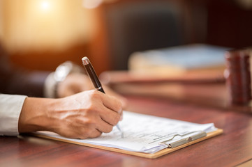 The lawyer is carrying a pen to write a case record in the courtroom